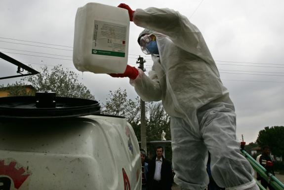 Un expert pr�pare un d�sinfectant contre la grippe aviaire dans une rue de Kiziksa, en Turquie.  | REUTERS/FATIH SARIBAS